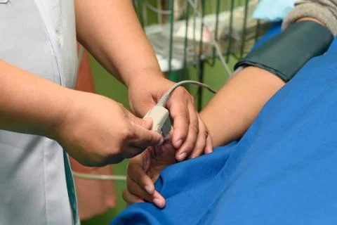 Doctor using pulse oximeter sensor on the patient hand Stock Photos
