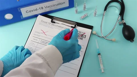 Doctor using red marker cross out covid 19 vaccination card anti vaccine concept Stock Footage 147442158