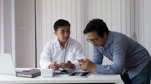 Doctor using smart phone and discuss with another doctor. Stock Footage 117329976