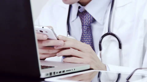 Doctor using smartphone and call Stock Footage 64722362