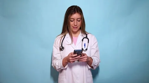 Doctor using smartphone on light blue background Stock Footage 297675062