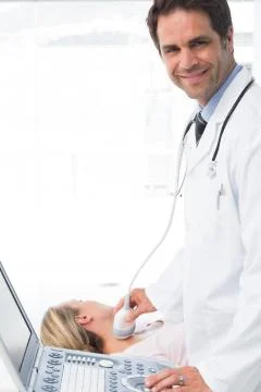 Doctor using sonogram on neck of patient Stock Photos