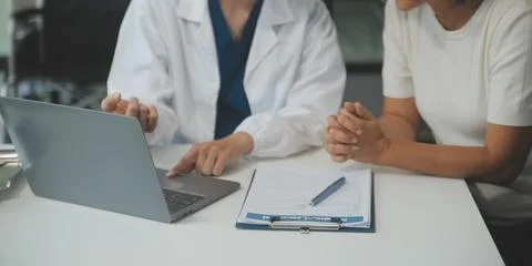 Doctor using sphygmomanometer with stethoscope checking blood pressure to a.. 写真素材