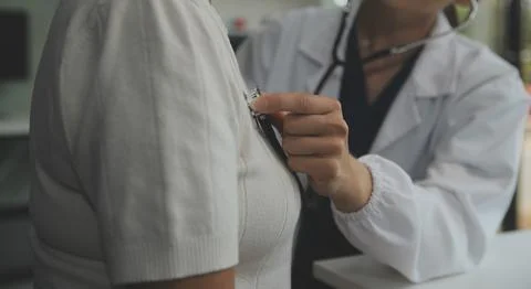 Doctor using sphygmomanometer with stethoscope checking blood pressure to a.. 写真素材
