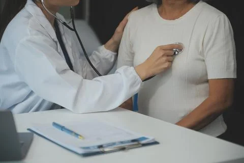 Doctor using sphygmomanometer with stethoscope checking blood pressure to a.. Stock Photos