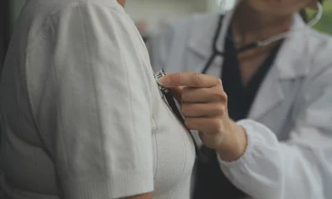 Doctor using sphygmomanometer with stethoscope checking blood pressure to a.. Foto stock