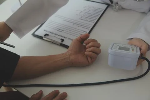 Doctor using sphygmomanometer with stethoscope checking blood pressure to a.. Foto stock