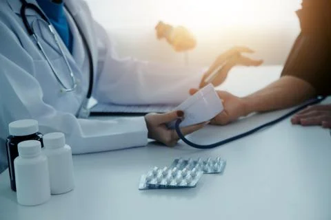 Doctor using sphygmomanometer with stethoscope checking blood pressure to a.. Stock Photos