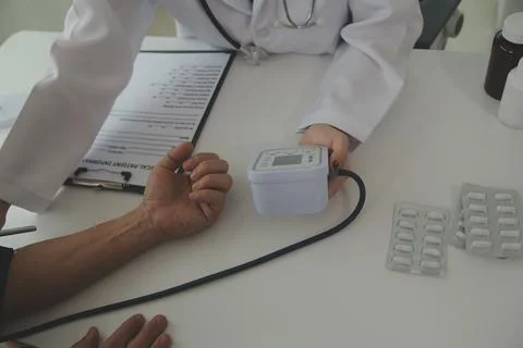 Doctor using sphygmomanometer with stethoscope checking blood pressure to a.. Foto stock