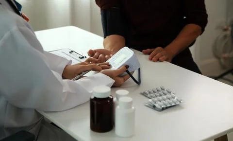 Doctor using sphygmomanometer with stethoscope checking blood pressure to a.. 写真素材