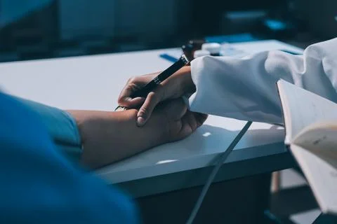 Doctor using sphygmomanometer with stethoscope checking blood pressure to a.. Stock Photos