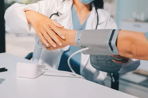 Doctor using sphygmomanometer with stethoscope checking blood pressure to a.. Foto stock