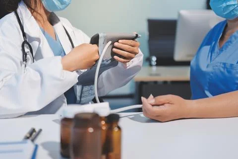 Doctor using sphygmomanometer with stethoscope checking blood pressure to a.. 스톡 사진