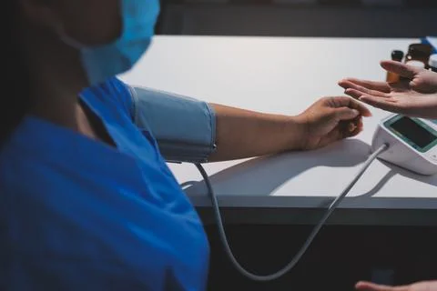 Doctor using sphygmomanometer with stethoscope checking blood pressure to a.. Foto stock