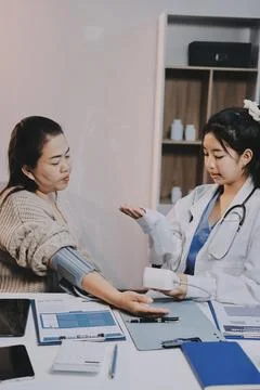 Doctor using sphygmomanometer with stethoscope checking blood pressure to a.. Foto stock