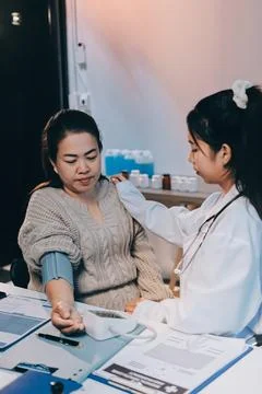 Doctor using sphygmomanometer with stethoscope checking blood pressure to a.. Foto stock