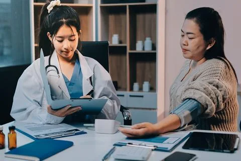 Doctor using sphygmomanometer with stethoscope checking blood pressure to a.. 스톡 사진