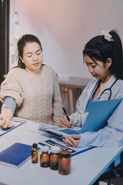 Doctor using sphygmomanometer with stethoscope checking blood pressure to a.. Foto stock