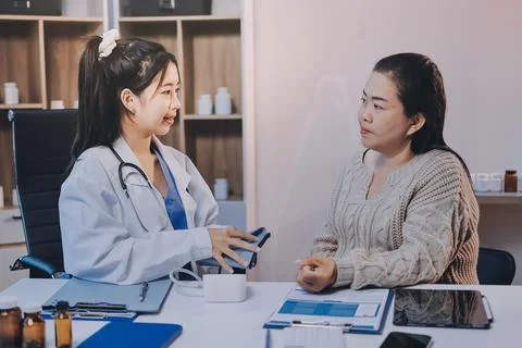 Doctor using sphygmomanometer with stethoscope checking blood pressure to a.. Stock Photos