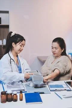 Doctor using sphygmomanometer with stethoscope checking blood pressure to a.. Fotos de archivo