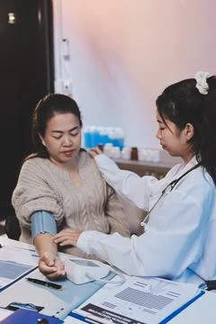 Doctor using sphygmomanometer with stethoscope checking blood pressure to a.. Foto stock