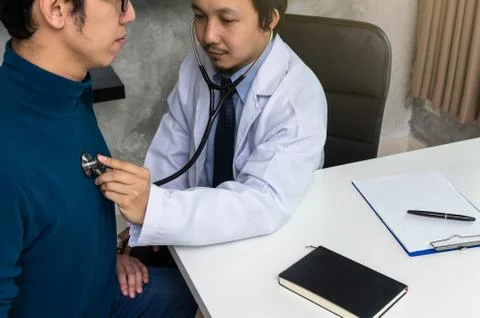 Doctor using stethoscope for checking heart rate and consulting with Patient  Stock Photos