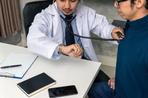 Doctor using stethoscope for checking heart rate and consulting with Patient  Foto stock