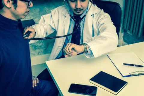 Doctor using stethoscope for checking heart rate and consulting with Patient  Stock Photos