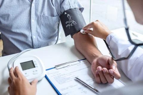 Doctor using stethoscope checking measuring arterial blood pressure on arm to Stock Photos
