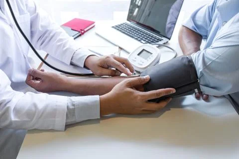 Doctor using stethoscope checking measuring arterial blood pressure on arm to Stock Photos