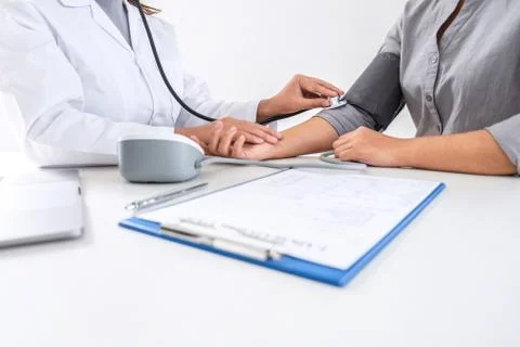 Doctor using stethoscope checking measuring arterial blood pressure on arm to 写真素材