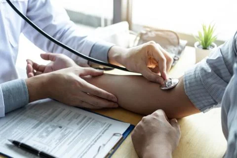 Doctor using a stethoscope checking patient with examining, presenting result Stock Photos
