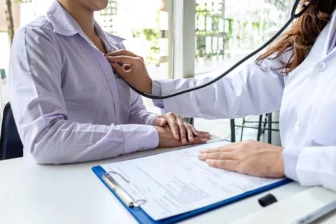 Doctor using a stethoscope checking patient about the problem of illness, sic Stock Photos