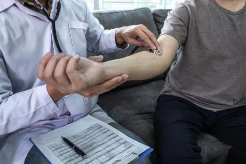 Doctor using a stethoscope checking patient about the problem of illness, sic Stock Photos