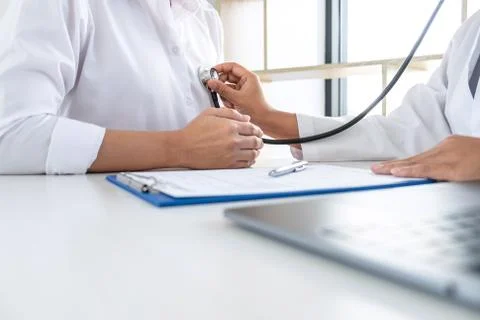 Doctor using a stethoscope checking patient about the problem of illness, sic Stock Photos