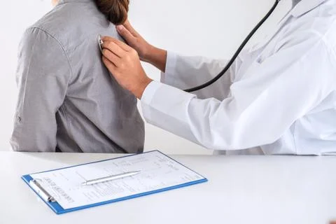 Doctor using a stethoscope checking patient about the problem of illness, sic Stock Photos