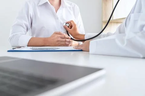 Doctor using a stethoscope checking patient about the problem of illness, sic Stock Photos