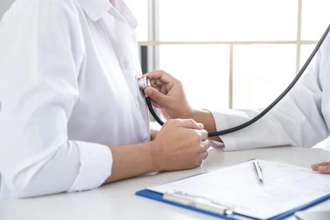 Doctor using a stethoscope checking patient with examining, presenting result Stock Photos