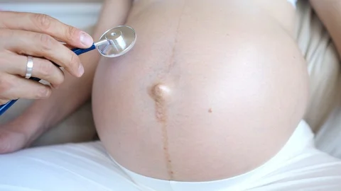Doctor Using Stethoscope To Hear Belly Of Pregnant Woman Video stock 121554262