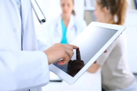 Doctor using tablet computer, close-up of hands at touch pad screen Stock Photos