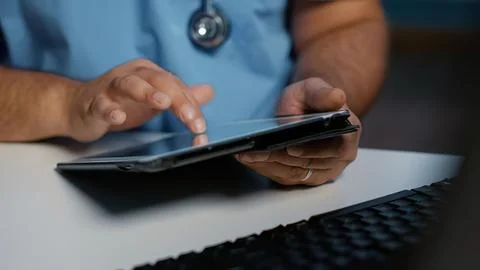 Doctor using tablet at desk with keyboard Stock Photos