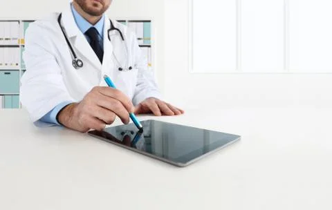 Doctor using tablet on desk Stock Photos