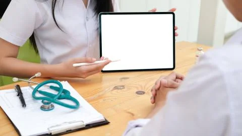 Doctor using tablet discussion something with patient. Stock Photos