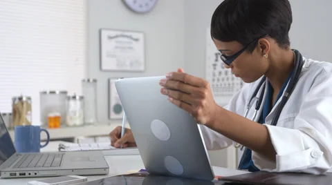 Doctor using tablet pc and laptop computer Stock Footage