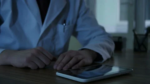 Doctor Using Tablet Pc At Night Stock-Footage 64061460