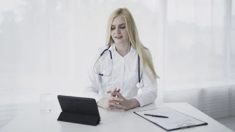 Doctor using tablet pc in office to video chat Stock Footage 77876197