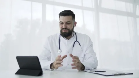 Doctor using tablet pc in office to video chat Stock Footage 77876747