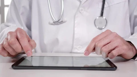 Doctor Using a Tablet Touch Screen Computer at His Desk Stock Footage 127844081