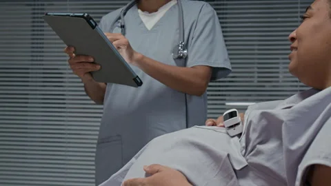 Doctor Using Tablet While Consulting Pregnant Black Woman in Hospital Stock Footage 336278300