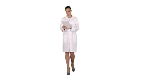 Doctor using tablet while walking on white background. Stock Photos